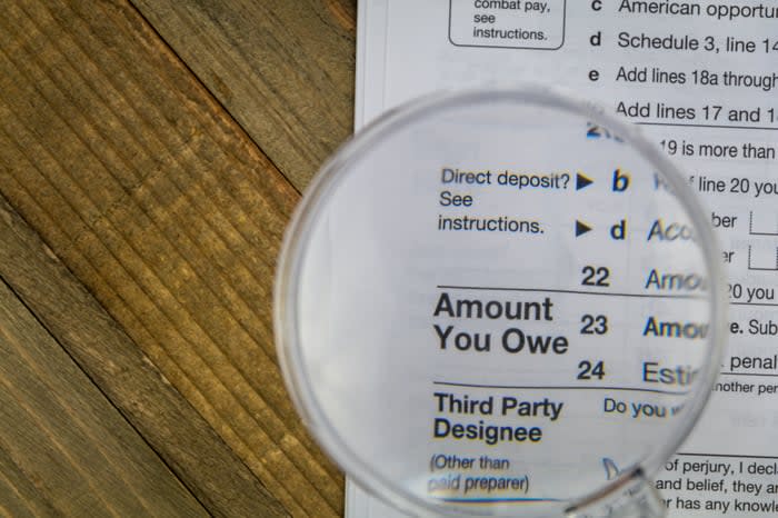 A magnifying glass held above the words, Amount you owe, on a state tax form. 